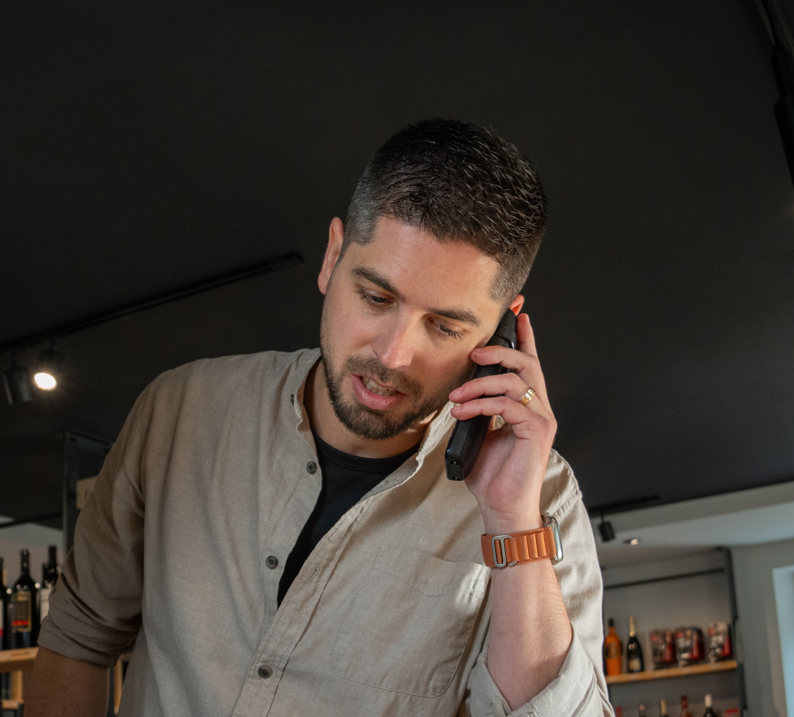 Maxime Pittet au téléphone, dans un espace de vente de vins.